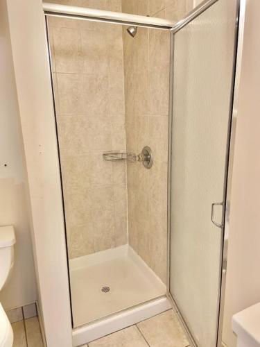 La salle de bains est pourvue d'une douche avec une porte en verre. dans l'établissement 222-Cozy Hoboken Apt on Main Street, à Hoboken