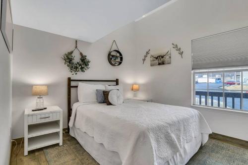 a white bedroom with a bed and a window at Fall Creek Condo near The Strip! in Branson