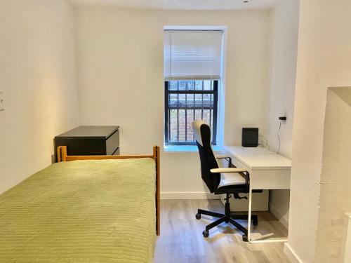 a bedroom with a bed and a desk and a window at 303-3Bedroom 2Bathroom in Hoboken