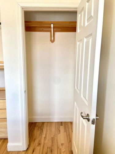 an empty room with a white door and wooden floors at 221-Modern 2B 2B on Hobokens Main Street in Hoboken
