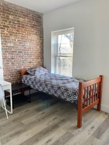 a bed in a room with a brick wall at 315-4Bedroom 2Bath W In Unit Washer in Hoboken