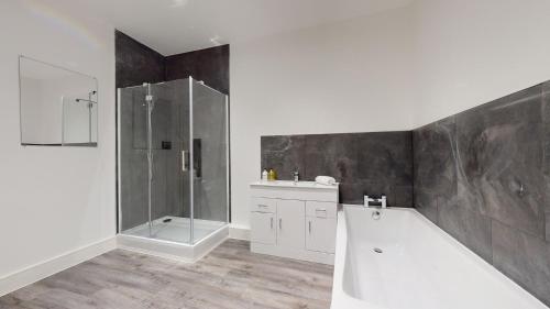 uma casa de banho com um chuveiro, uma banheira e um lavatório. em Spacious three bedroom apartment with Valley views em Abertillery