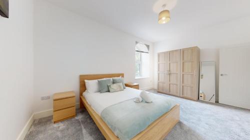 um quarto com uma cama grande e um armário de madeira em Spacious three bedroom apartment with Valley views em Abertillery