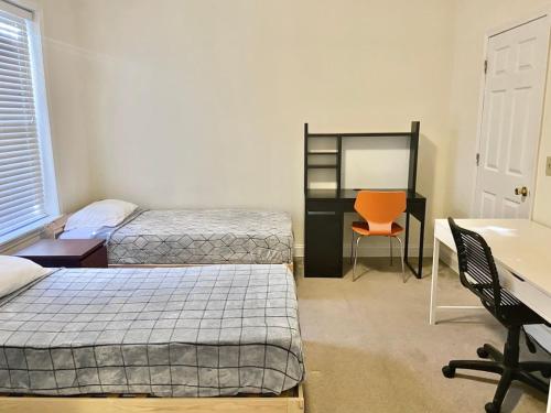 Un dormitorio con dos camas y un escritorio y una silla. en 118-1 GB Internet Great Summer 2 Bed 2 Bath Stay, en Hoboken