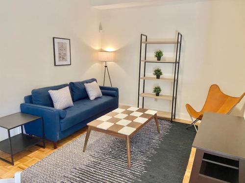 uma sala de estar com um sofá azul e uma mesa em 103-2 Bed Modern Apt in the Heart of Hoboken em Hoboken