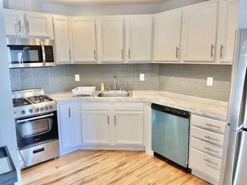 uma cozinha com armários brancos e um lavatório em 212-Two Bedroom Apt.with Patio and Free Laundry em Hoboken