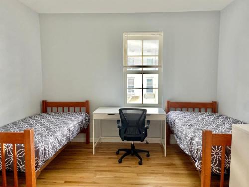 um quarto com 2 camas e uma secretária com uma cadeira em 212-Two Bedroom Apt.with Patio and Free Laundry em Hoboken