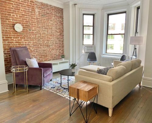 ein Wohnzimmer mit Sofa und Ziegelwand in der Unterkunft 301-Two Bedroom Apartment in Hoboken in Hoboken