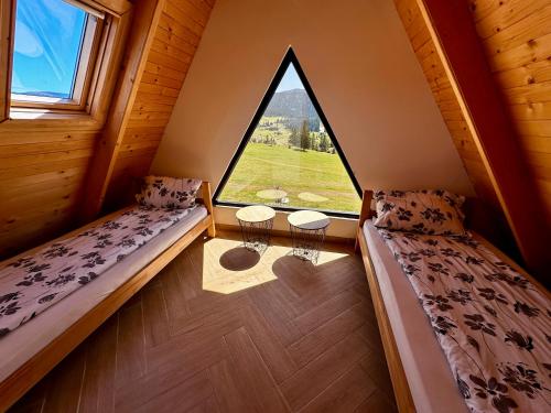 2 Betten in einem Zimmer mit einem großen Fenster in der Unterkunft AJLA in Vlasic