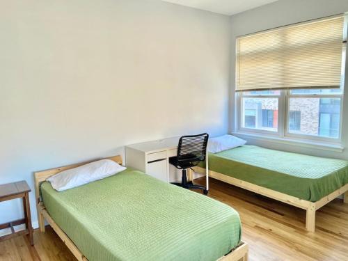 um quarto com 2 camas, uma secretária e uma cadeira em 205-Bright and Airy 2Bed 2 Bath Apartment in Hoboken em Hoboken