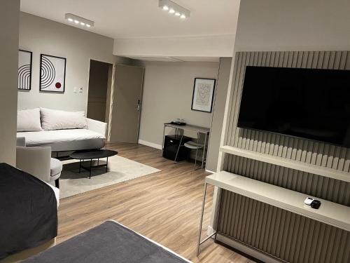 un soggiorno con TV a schermo piatto e divano di Guemes Hotel & Spa a Salta