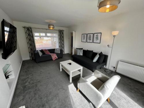 ein Wohnzimmer mit einem Sofa und einem Tisch in der Unterkunft Spacious Family home in great location in Cardiff in Cardiff
