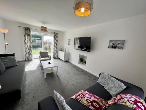 - un salon avec un canapé et une chaise dans l'établissement Spacious Family home in great location in Cardiff, à Cardiff