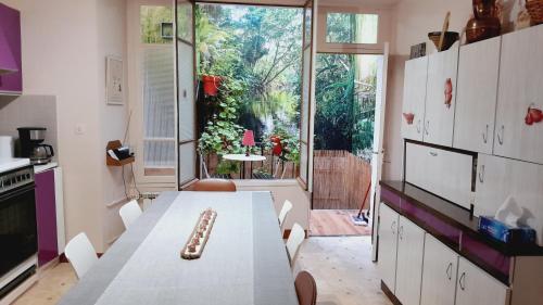 une cuisine avec une table et une grande fenêtre dans l'établissement Grande maison en Aubrac, à Chaudes-Aigues