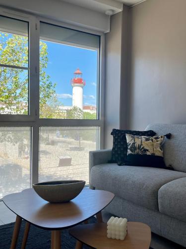 un salon avec un canapé et un phare dans l'établissement L'amarrage éphémère, à La Rochelle