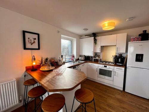 a kitchen with a wooden table and some chairs at Two bedroom apartment in Barry-close to beach in Barry