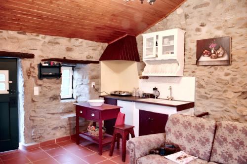 uma cozinha com um lavatório e uma bancada em One bedroom house with enclosed garden at Souto da Casa em Souto da Casa