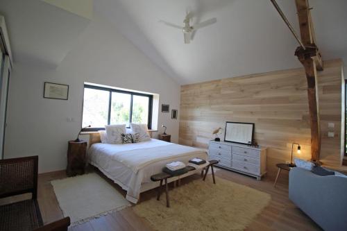 a bedroom with a bed and a dresser and a television at Kernad in Bersac-sur-Rivalier