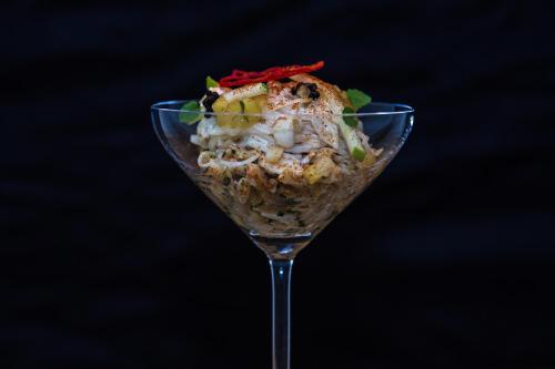 a desert in a martini glass on a black background at Hôtel Saint-Alban in Nézignan-lʼÉvêque