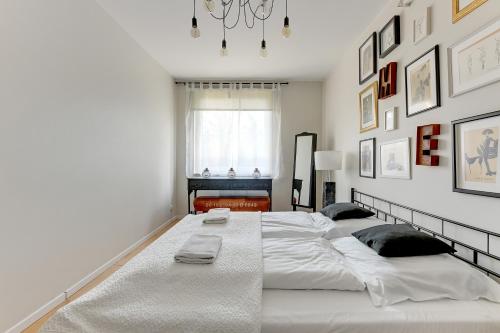 a bedroom with a large white bed with two pillows at Platinium Kartuska Modern in Gdańsk