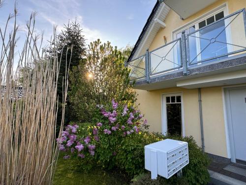 Una casa con una cómoda blanca en el patio. en Ostseegarten Nienhagen, en Ostseebad Nienhagen