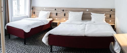 two beds with white pillows in a room at Good Morning City Copenhagen Star in Copenhagen