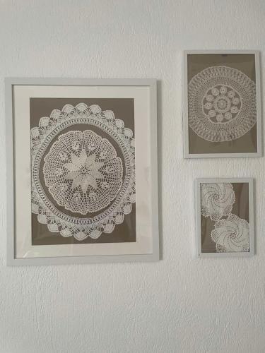 three framed pictures on a white wall at Nepheli in Paralia Katerinis