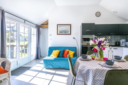 un salon avec une table et un canapé bleu dans l'établissement Les gites de Château Trompette, à Le Fenouiller