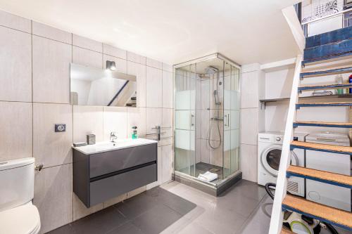 a bathroom with a sink and a washing machine at GuestReady - Modern Nest near Parc André Citroën in Paris