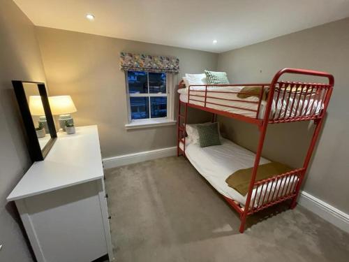 巴德來索特頓的住宿－Nomi Homes - Budleigh Salterton - Beach - Sleeps 4，客房设有两张双层床和一张书桌。