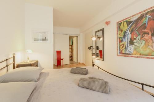 una camera da letto con un letto e un dipinto sul muro di Appartement spacieux à 15 minutes du jet d'eau a Ginevra