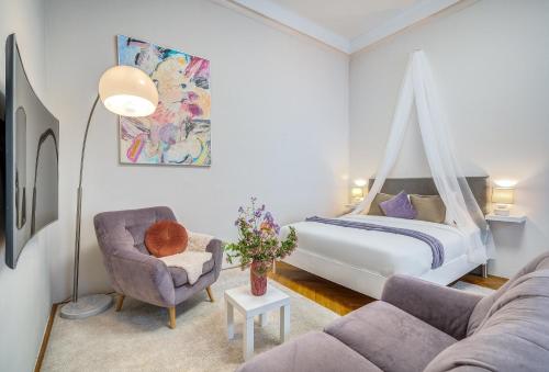 a bedroom with a bed and a couch and a chair at Székely Bertalan Residence in Budapest