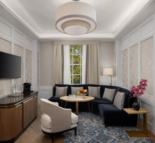 uma sala de estar com um sofá e uma mesa em The Biltmore Mayfair em Londres