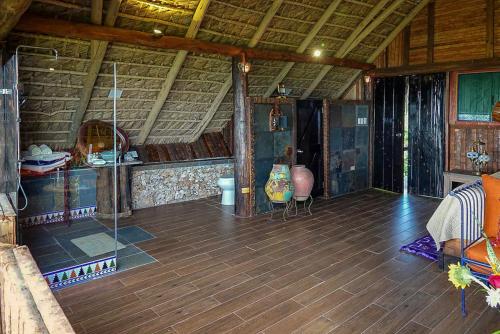 a large room with a wooden floor and a ceiling at Casa El Paraiso, Eco Lodge in Santa Bárbara de Samaná