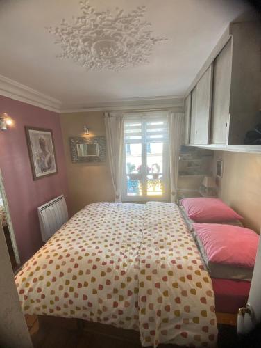 - une chambre avec un grand lit et des draps roses dans l'établissement Apartment Gugu Montmartre, à Paris