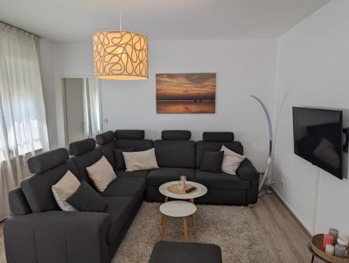 a living room with a black couch and a table at Ferienwohnung Amphora in Wunstorf
