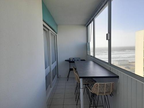 un balcon avec une table et des chaises et l'océan dans l'établissement Appartement à 100m de la plage avec parking et petits animaux admis - FR-1-324A-38, à Saint-Hilaire-de-Riez