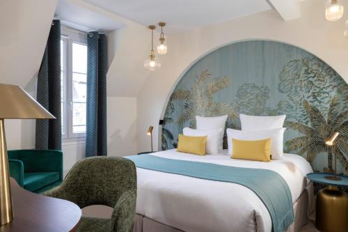 een slaapkamer met een groot bed met gele kussens bij Hotel Elysées Bassano in Parijs