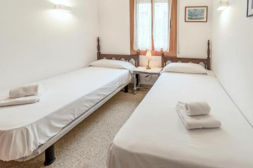 a group of three beds in a room at Sant Carles 22 - apartamento con vistas al mar in Girona