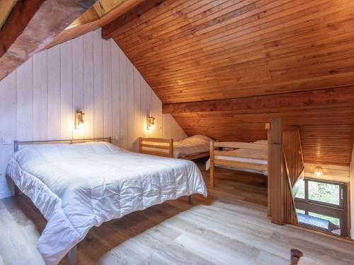- une chambre dans une cabane en rondins avec un lit et une fenêtre dans l'établissement T2 rénové avec terrasse, parking privé, local vélos à Cauterets - FR-1-401-290, à Cauterets