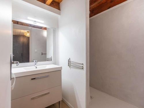 une salle de bain avec un lavabo et un miroir dans l'établissement T2 rénové avec terrasse, parking privé, local vélos à Cauterets - FR-1-401-290, à Cauterets