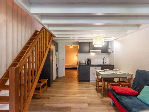 Il comprend une cuisine et un salon avec une table et un escalier. dans l'établissement T2 rénové avec terrasse, parking privé, local vélos à Cauterets - FR-1-401-290, à Cauterets