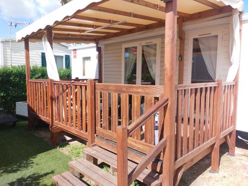 une terrasse en bois avec pergola sur une maison dans l'établissement MOBIL HOME LE COCOONING, à Valras-Plage