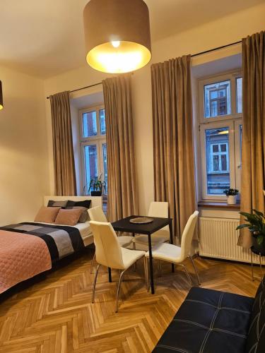 1 dormitorio con 1 cama, mesa y sillas en Apartamenty Lenart, en Cracovia