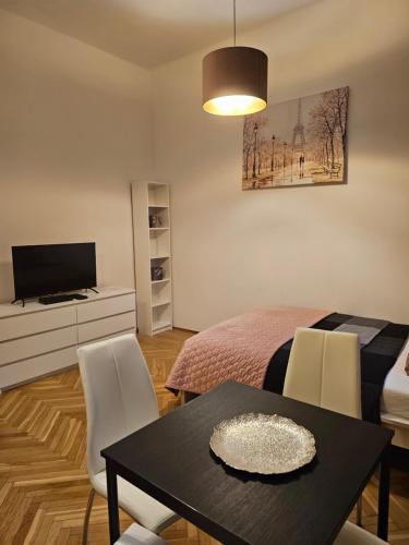 a living room with a dining table and a bedroom at Apartamenty Lenart in Krakow