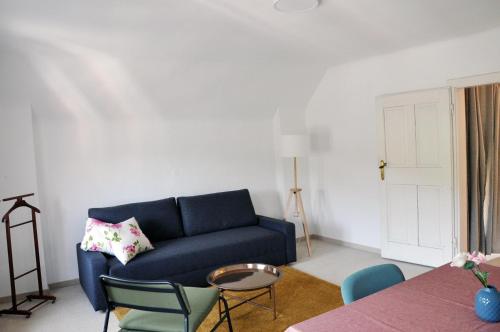 a living room with a blue couch and chairs at Wohnen bei Schörgi in Grein