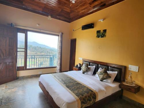 a bedroom with a large bed with a large window at Prem BnB Palampur in Pālampur
