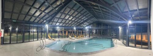 a large swimming pool in a building with a ceiling at TERMAS PISMANTA Hotel & Spa in Las Flores