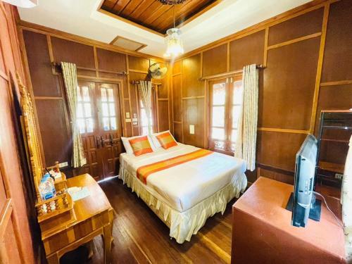 a bedroom with a bed and a desk and a television at Grand Sea Beach Resort in Haad Pleayleam