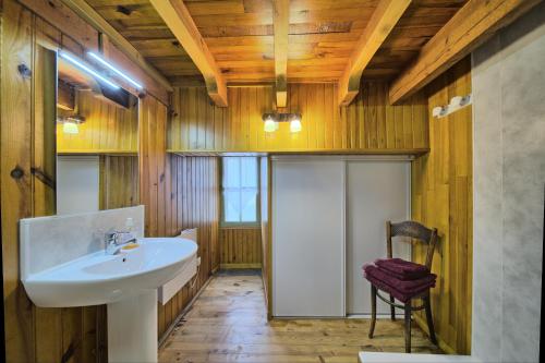 baño con lavabo y techo de madera en Loft en duplex avec balcon et vue, en Arreau